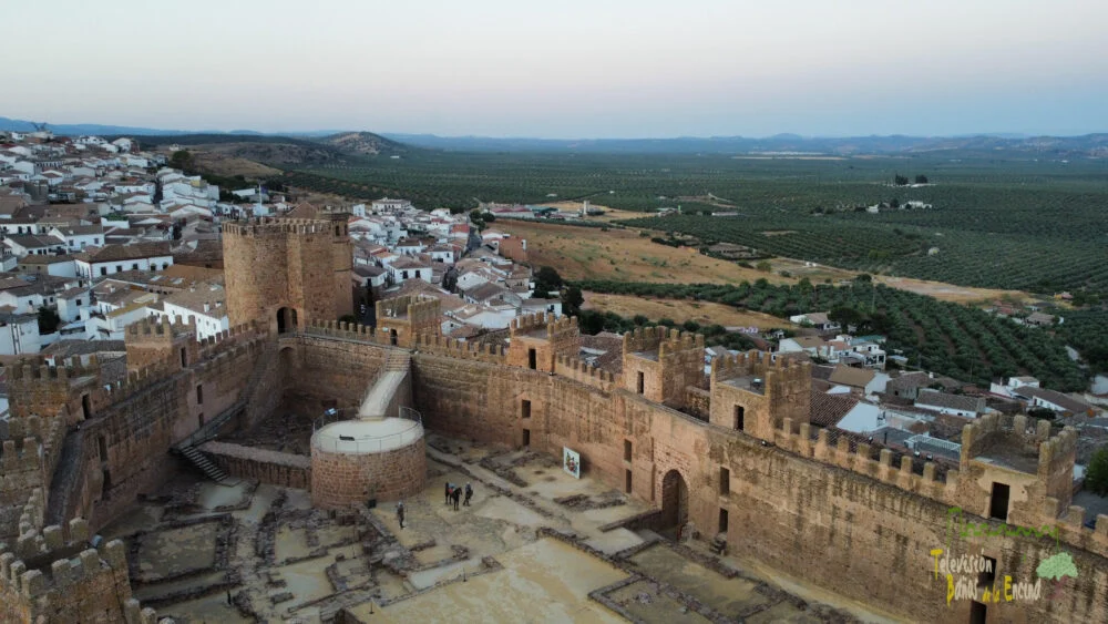 Grupo de visitantes con guía recorriendo el patio de armas del castillo